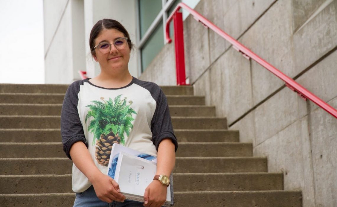 Soraya-Bellou-On-campus-stairs-with-books-medium-1024x683